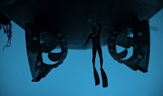 Free diver under the hull of EDT Niovi while anchored